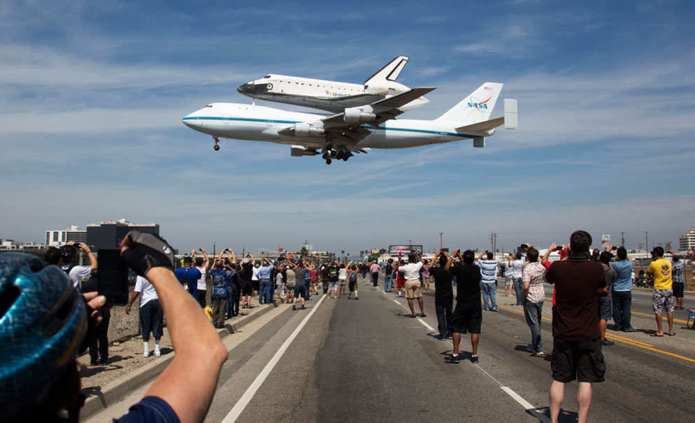 The Endeavour flys above a crowd of onlookers